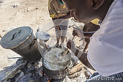 African women cooking porridge over fire Editorial Stock Photo