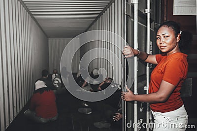African women Opening the door of a container, inside of which several people were sitting Stock Photo
