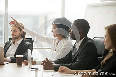 African woman raising hand to ask question at team training Stock Photo