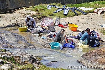 African women washing clothes on a river. Washed clothes are lie Editorial Stock Photo