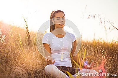 African young woman in nature sitting in yoga position lYoga Stock Photo