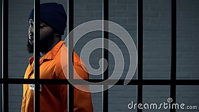 Afro-american criminal in jail cell serving sentence, punishment for kidnapping Stock Photo