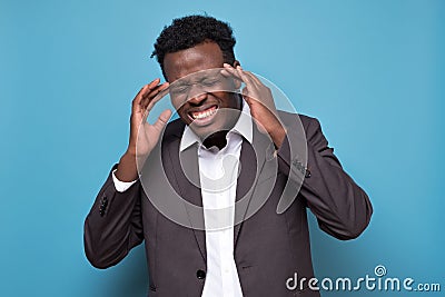 Afro american man with strict headache in studio on blue isolated background Stock Photo