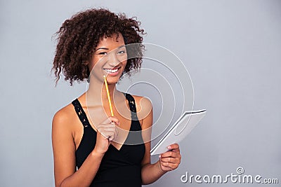 Afro american woman holding notebook with pencil o Stock Photo