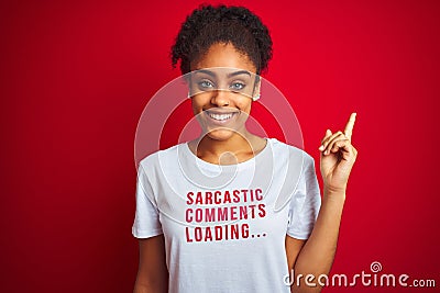 Afro american woman wearing funny t-shirt with irony comments over isolated red background very happy pointing with hand and Stock Photo