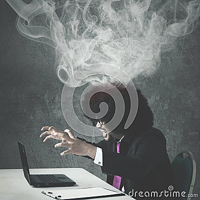 Afro businessman angry with his broken laptop Stock Photo