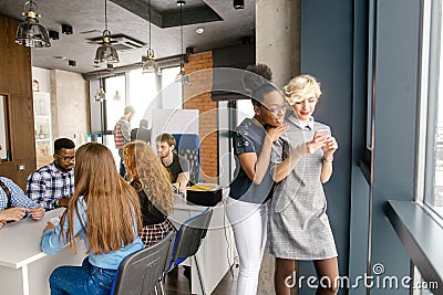 Afro and Caucasian attractive employees are reading business information Stock Photo