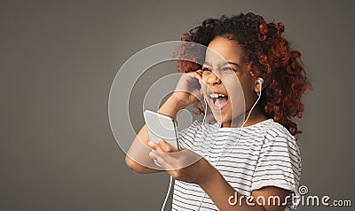 Afro child girl in earphones at gray studio background Stock Photo