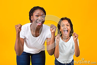 Afro family celebrating success, clench fists and exclaim Stock Photo