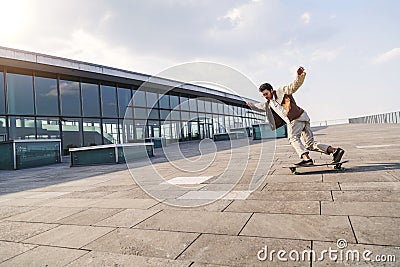 Afro guy rides fast on his skateboard over square Stock Photo