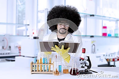 Afro scientist reading a book in laboratory Stock Photo