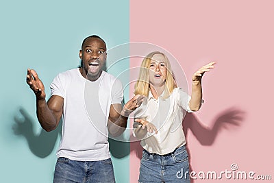 The afro surprised couple watching sports match on tv at home, successful game. Different emotions concept. Studio shot Stock Photo