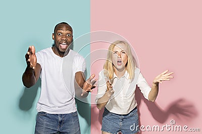 The afro surprised couple watching sports match on tv at home, successful game. Different emotions concept. Studio shot Stock Photo