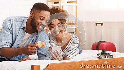 Afro Tourists Booking Tickets Online, Using Phone Stock Photo