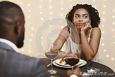 Bored afro woman attending first date at restaurant Stock Photo