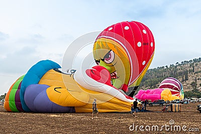 The maintenance team inflates the hot air balloon on the ground before the flight at the hot air balloon festival Editorial Stock Photo