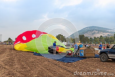 The maintenance team inflates the hot air balloon on the ground before the flight at the hot air balloon festival Editorial Stock Photo