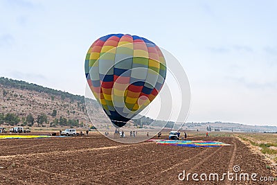 Pilots of a striped air hot balloon are preparing to fly out at the festival of ais hot balloons Editorial Stock Photo