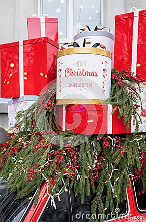 Against the background of a Christmas tree and decorations, there are many large, bright and beautiful red gift boxes. Christmas Editorial Stock Photo