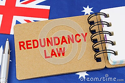 Against the background of the flag of Australia lies a notebook with the inscription - REDUNDANCY LAW Stock Photo