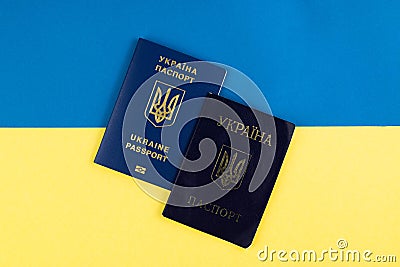 Against the background of the Ukrainian yellow-blue flag, a passport of a citizen of Ukraine and a foreign passport Stock Photo