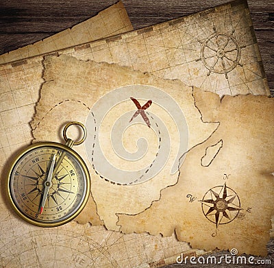 Aged brass nautical compass on table with old maps Stock Photo