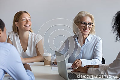 Aged business coach provides information to interns young company staff Stock Photo