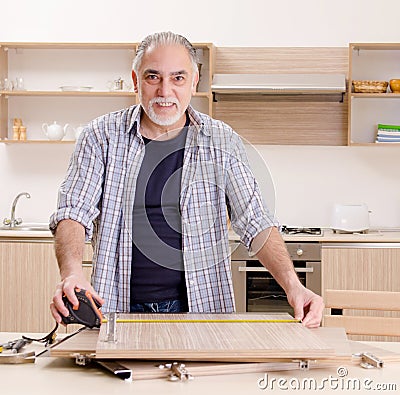 Aged contractor repairman working in the kitchen Stock Photo