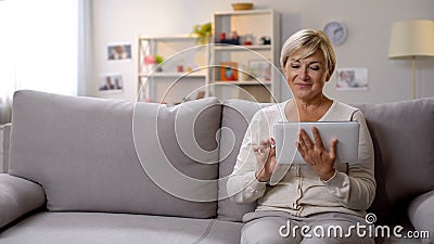 Aged female using tablet, surfing net, leisure time spending, social media Stock Photo