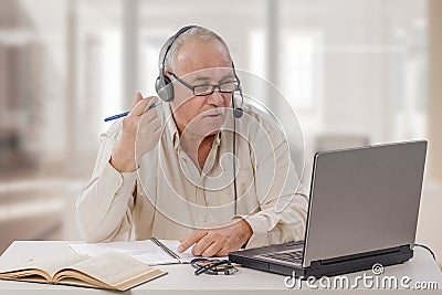 Aged freelance male tutor working online Stock Photo