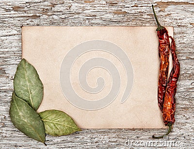 Aged sheet of paper with dry bay leaves and pepper Stock Photo
