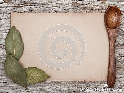 Aged sheet of paper, wooden spoon and dry bay leaves Stock Photo