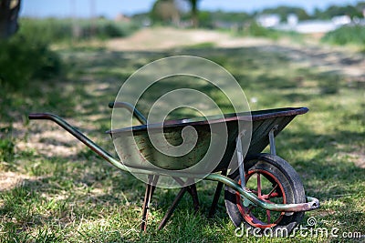 a old wheelbarrow and wooden wheel barrow are pictured outside Stock Photo