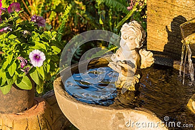 .Aged white angel Cupid sculpture sitting water fountain.Thailand Stock Photo