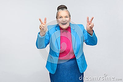 Aged woman laugh and showing peace or victory sign at camera Stock Photo