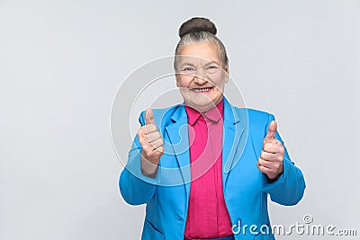 Aged woman toothy smiling and showing like sign Stock Photo