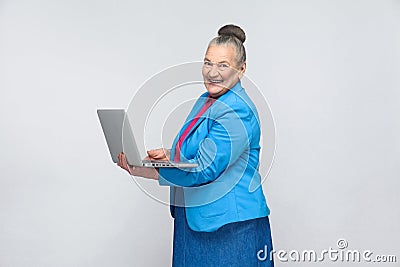 Aged woman work in computer and toothy smiling Stock Photo