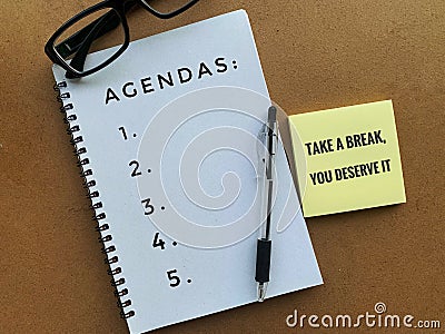 Agendas text on a note pad with pen, sticky note and glasses background. Stock Photo