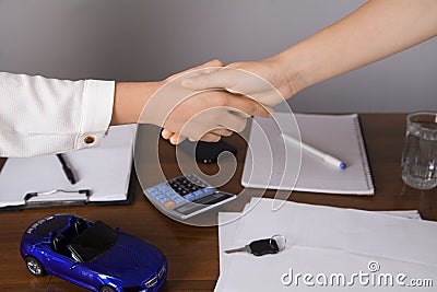 Agent car salesman informs about the car purchase contract. Two women. Seller and the buyer shake hands Stock Photo