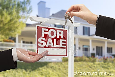 Agent Handing Over House Keys in Front of New Home Stock Photo