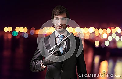 Agent or spy with gun at night. Crime concept Stock Photo