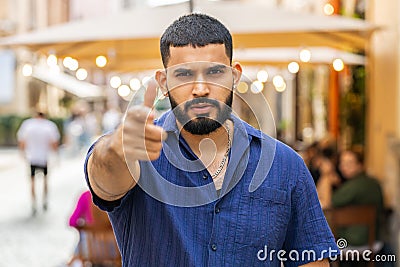 Aggressive angry indian man upset sad dissatisfied mad looking at camera in urban city street Stock Photo