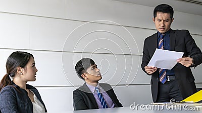 Aggressive boss businessman holding paper file work and complain staff and colleague in meeting conference room Stock Photo