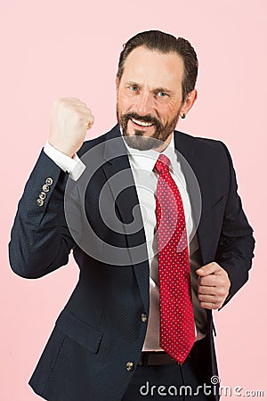 Aggressive businessman with beard wearing a blue suit and red tie fighting with angry expression. Angry man face emotion Stock Photo