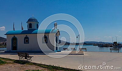 Aghios Nikolaos Orthodox Church and Mediterranean Fishing Boats on Water in Euboea - Nea Artaki, Greece Stock Photo