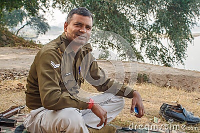 AGRA, INDIA - DECEMBER 2012: Indian police officer looking at camera on a river bank Editorial Stock Photo