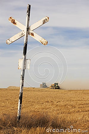 Agrarian tractors at the field with railway sign. Stock Photo