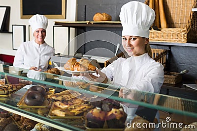 Agreeable woman and young girl reccomending pastry Stock Photo