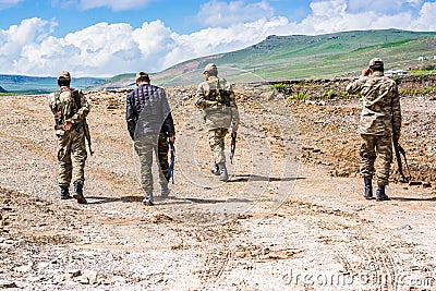 Agri, Turkey - May 24, 2017. Turkish soldiers walking on muddy road Editorial Stock Photo