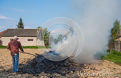 Work in the garden. Farmer burning dried branches Stock Photo